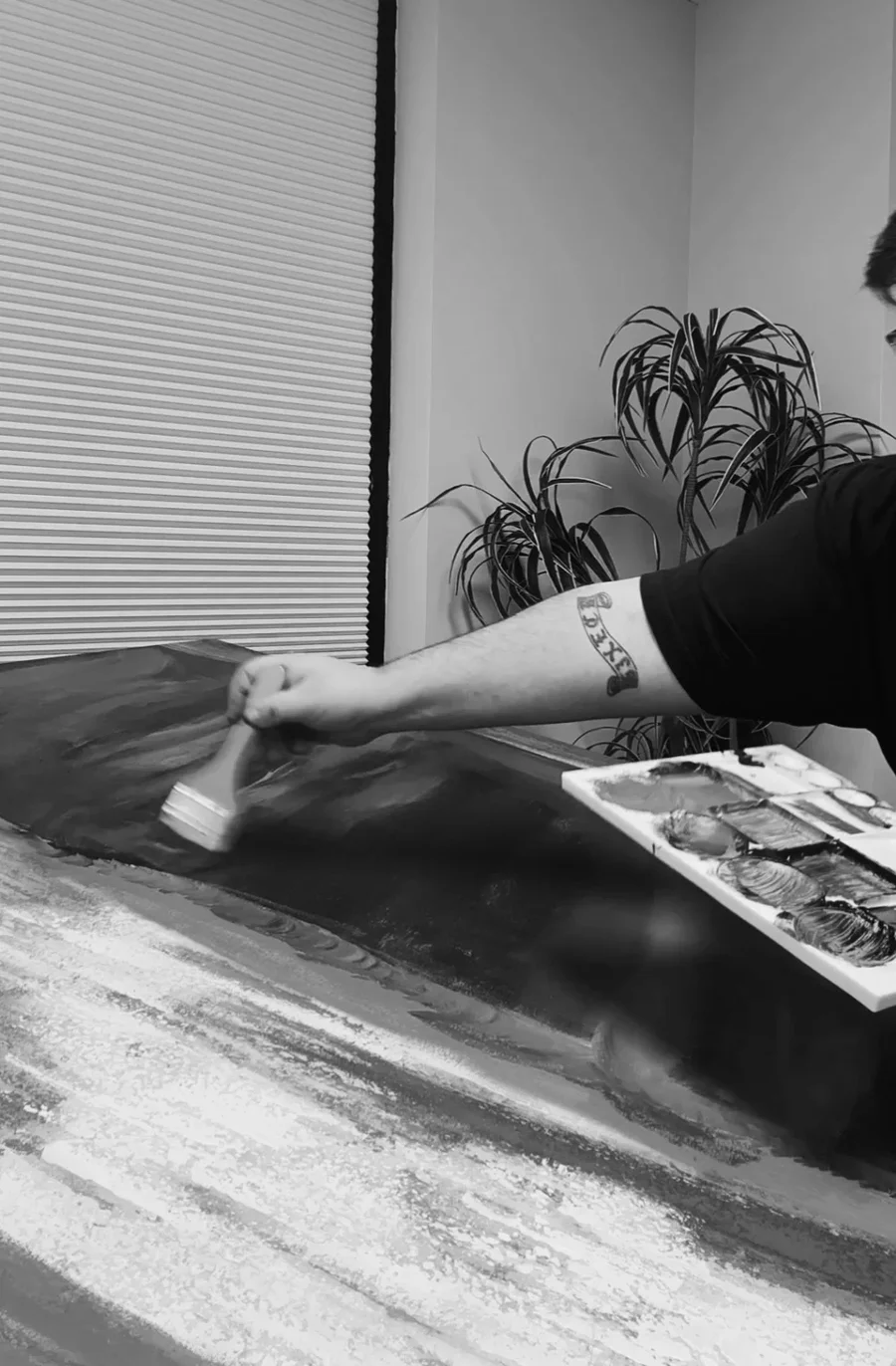 Aaron Michael painting a large canvas in his studio